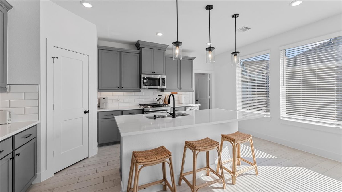 Kitchen with island – Modern kitchen with center island and seating, part of midterm rentals for traveling professionals.