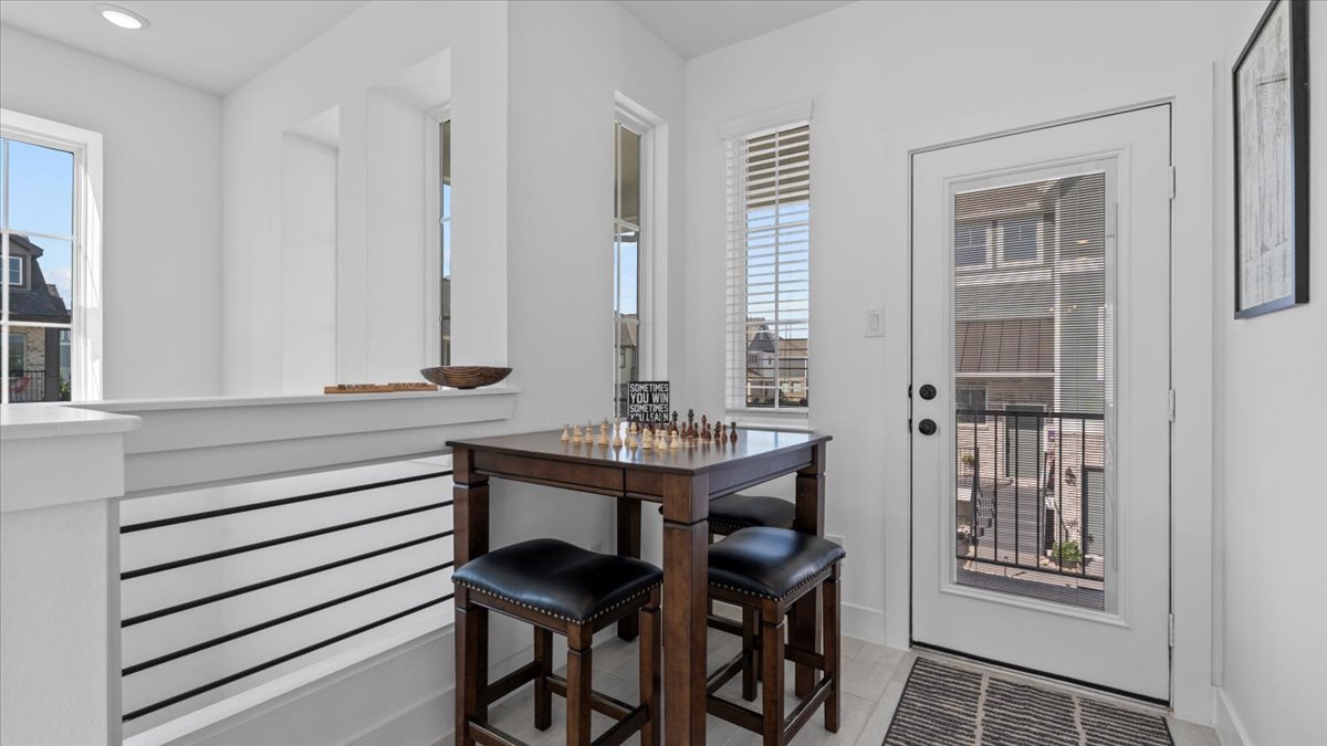 Cozy upstairs nook with chess table and natural light in a furnished home rental in Cypress, Texas.