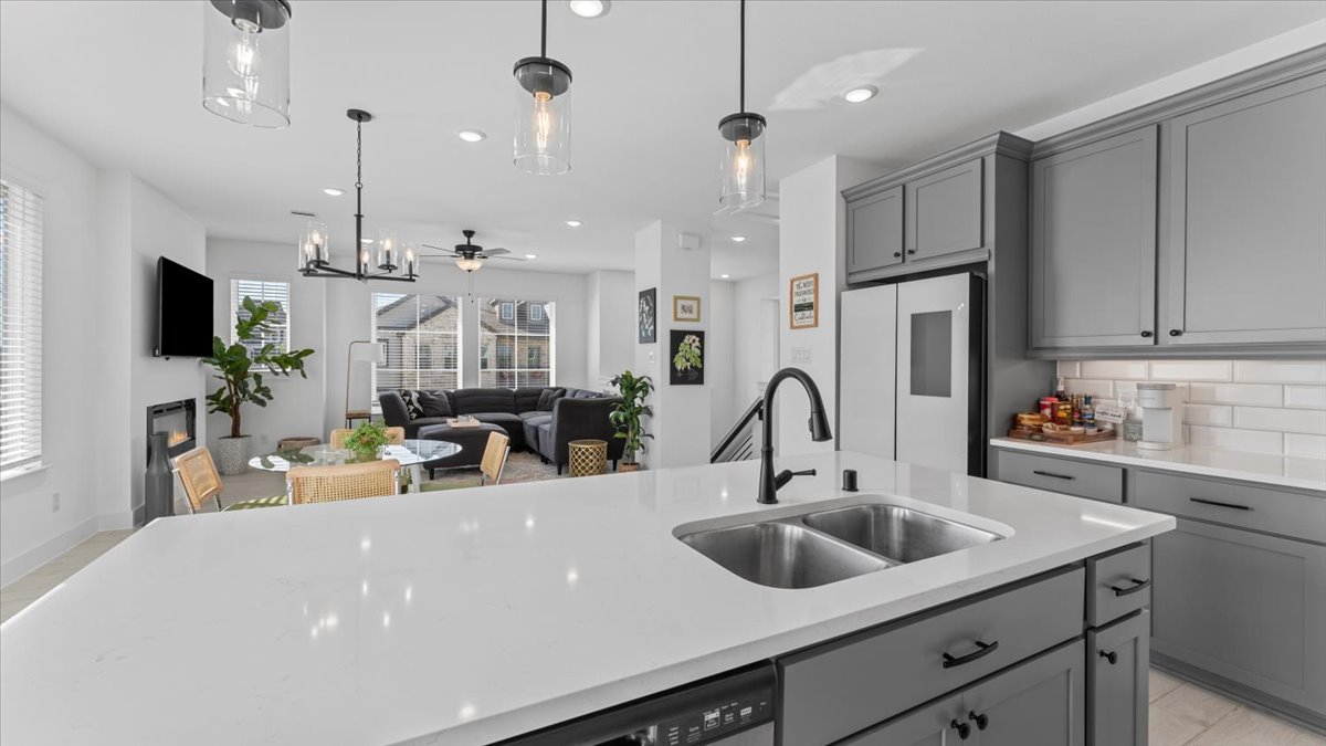Kitchen with stainless steel appliances. Modern kitchen with gas stove, microwave, and grey cabinets in a furnished home rental in Cypress Texas.