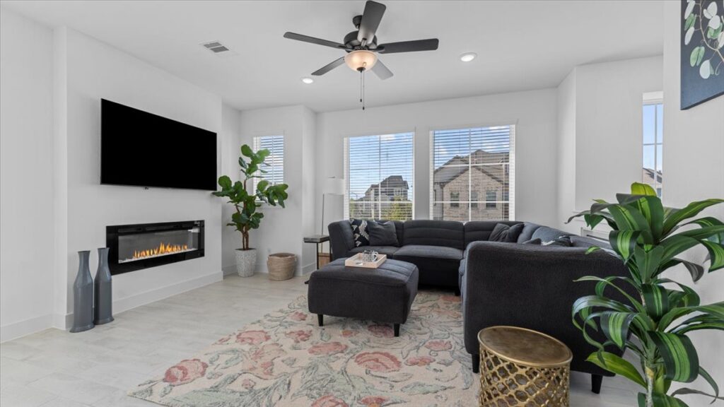 Cozy living room with fireplace and large windows in midterm rentals in Cypress TX.
